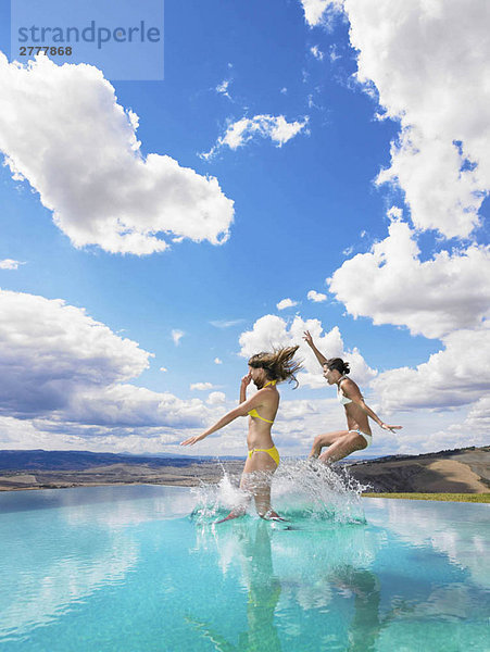 Frauen springen im Schwimmbad