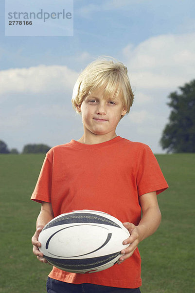 Junge hält Rugbyball in der Ablage