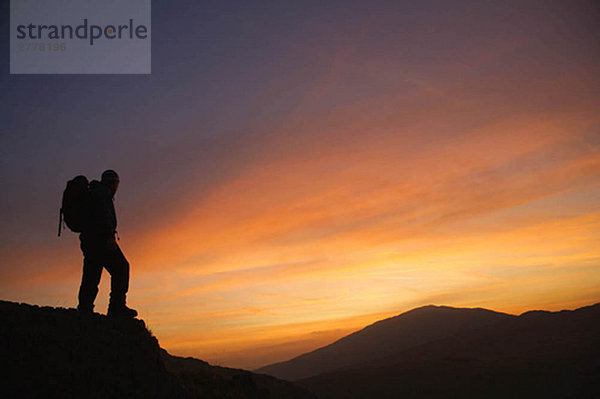 Wanderer mit Blick auf den Sonnenaufgang.