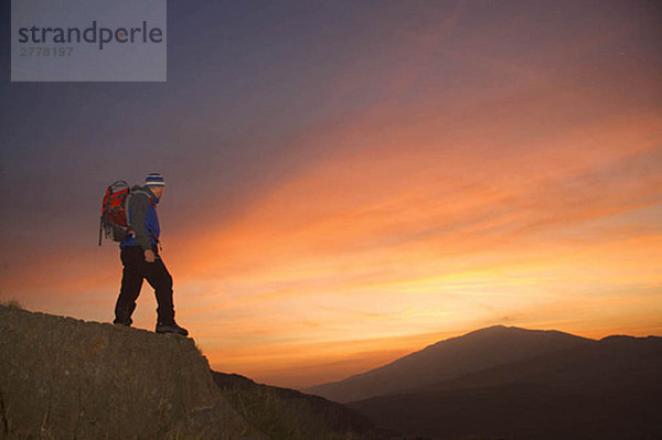 Wanderer mit Blick auf den Sonnenaufgang.