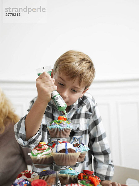 Junge macht Cupcakes
