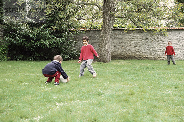 Jungen spielen mit Ball im Hof
