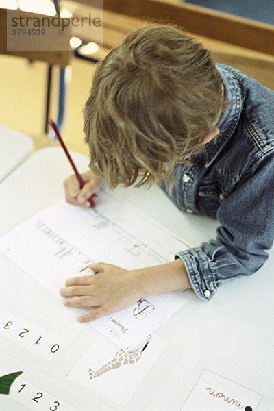 Kind bei der Arbeit an der Handschriftübung  Hochwinkelansicht