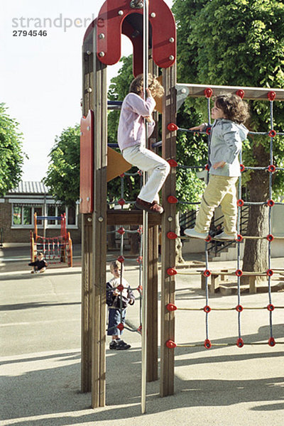 Kinder beim Spielen im Klettergerüst in der Pause