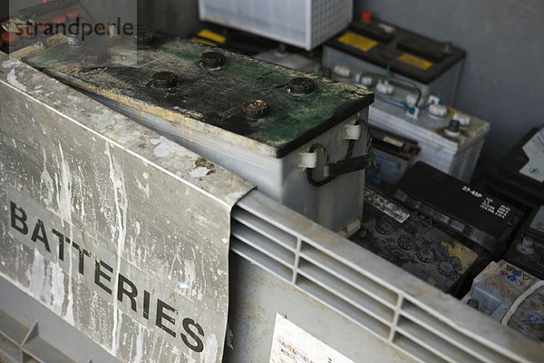 Alte Autobatterien im Papierkorb gestapelt