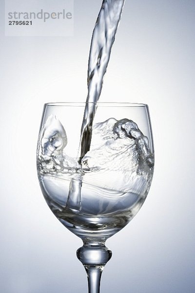 Wasser in Stielglas eingiessen