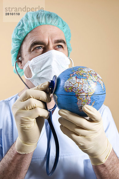 Männlich Chirurg Globus mit Stethoskop Untersuchung