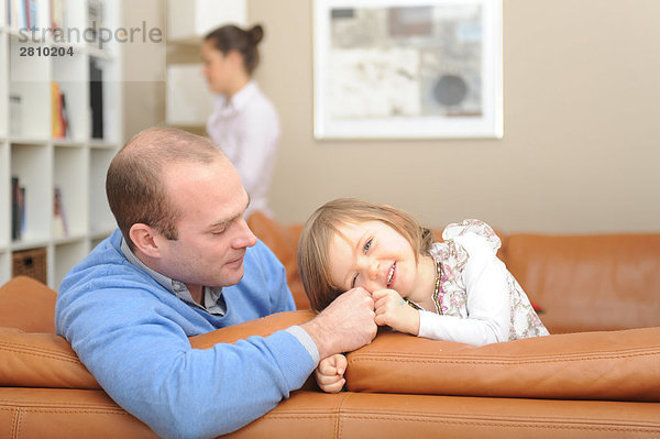 Mädchen mit ihrem Vater auf Couch sitzen