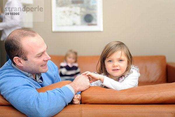 Porträt von Mädchen mit ihrem Vater auf Couch sitzen