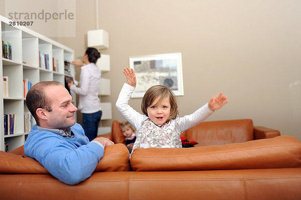 Girl playing auf Couch mit ihrem Vater