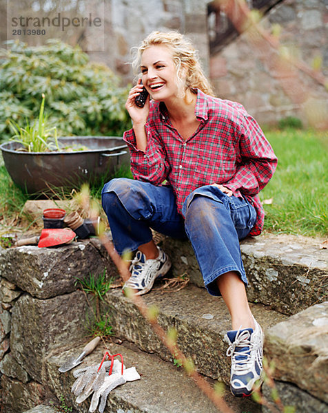 Handy sitzend Frau sprechen Garten