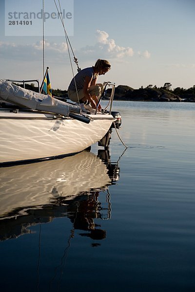 Eine Frau sitzt auf einem Segelboot Östergötlands Schweden.