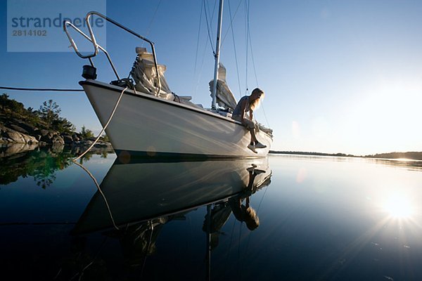 Eine Frau sitzt auf einem Segelboot Östergötlands Schweden.