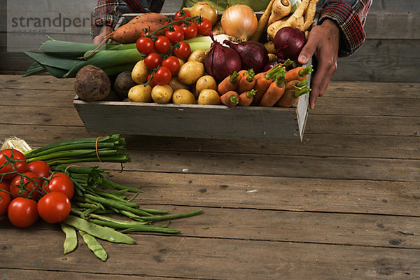 Mann Frische Gemüse halten Behälter