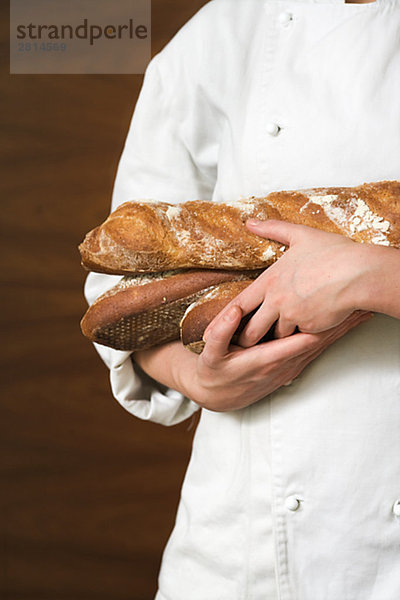 Eine Frau hält Laib Brot Französisch Schweden.