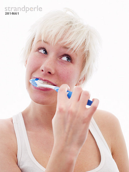 Eine skandinavische Teenagerin putzen ihre Zähne.
