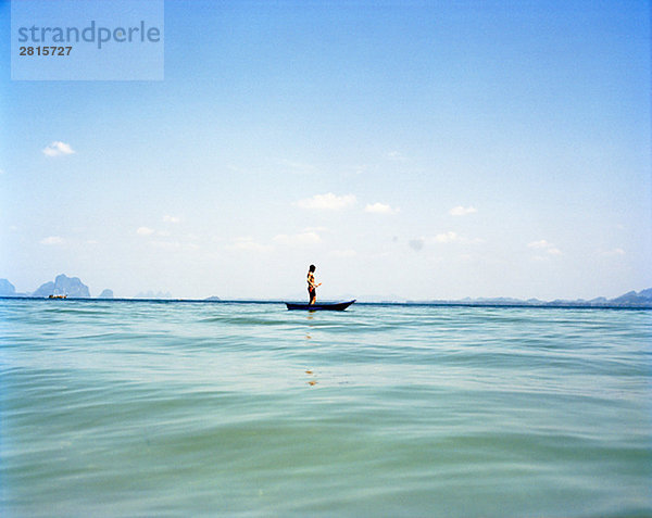 Ein Mann in einem kleinen Boot auf das blaue Meer Thailand.