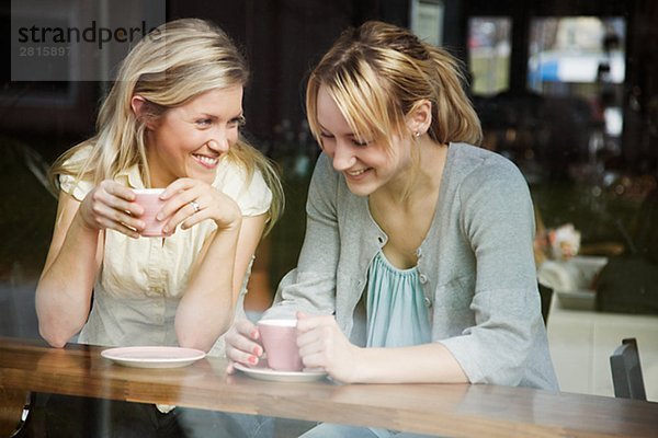 Zwei Frauen hatte einen Becher Kaffee in einem Café Schweden.