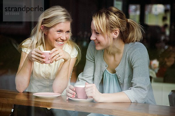 Zwei Frauen hatte einen Becher Kaffee in einem Café Schweden.