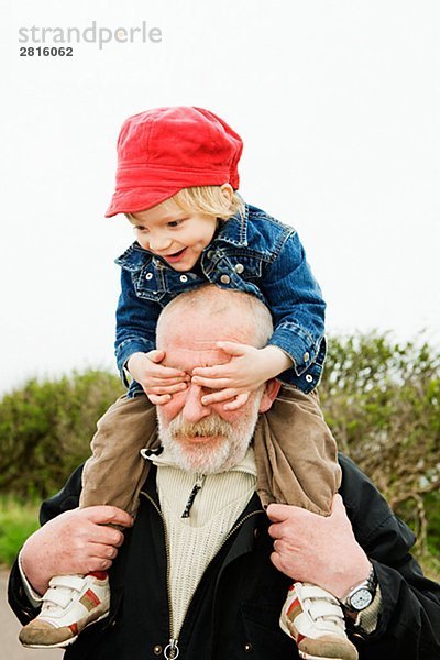 Großvater seine Enkel auf seinen Schultern Schweden tragen.
