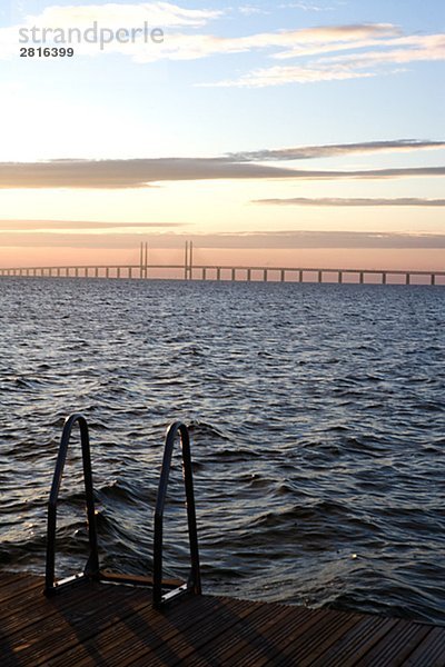 Silhouette von einer Mole mit Oresundsbron im Hintergrund Skane Schweden.