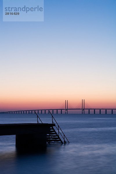 Silhouette von einer Mole mit Oresundsbron im Hintergrund Skane Schweden.