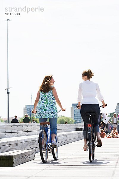 Zwei Frauen fahren Fahrrad Skane Schweden.