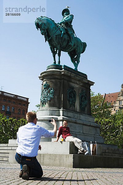 Zwei Männer durch eine Statue in Malmö Schweden.
