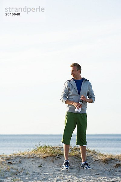 Ein Mann nach joggen am Strand Malmö Schweden ruhelosigkeit.