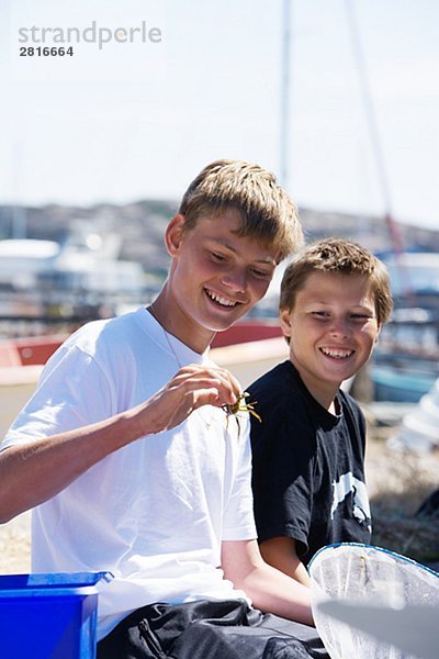 Zwei jungen und eine Krabbe Smogen Bohuslan Schweden.