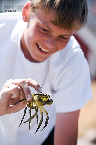 Ein Teenager eine Krabbe Schweden halten.