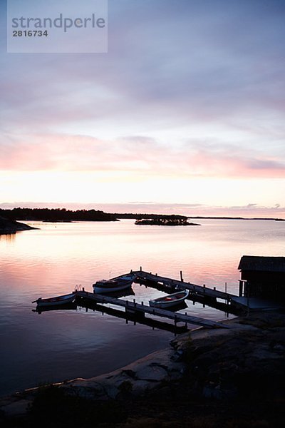 Ein Bootshaus in den Sonnenuntergang in den Schären von Stockholm Schweden.