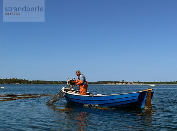 Ein Fischerei-Mann in einem Boot Schweden.