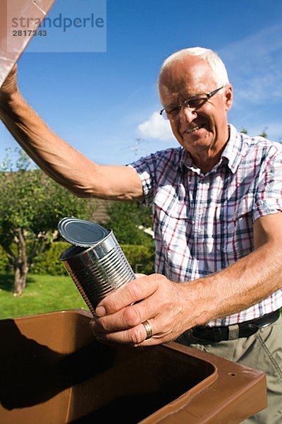 Ein älterer Mann hält eine Dose von einem Auffangbehälter Schweden.