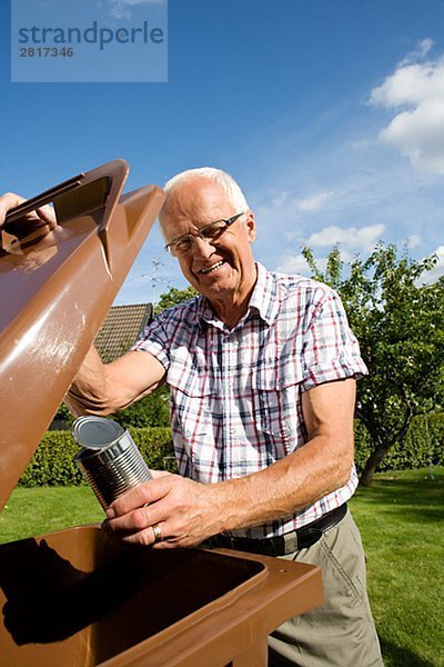 Ein älterer Mann hält eine Dose von einem Auffangbehälter Schweden.