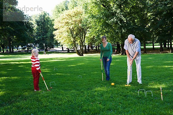 älterer Mann Mädchen und Frau Krocket im Park Schweden spielen.