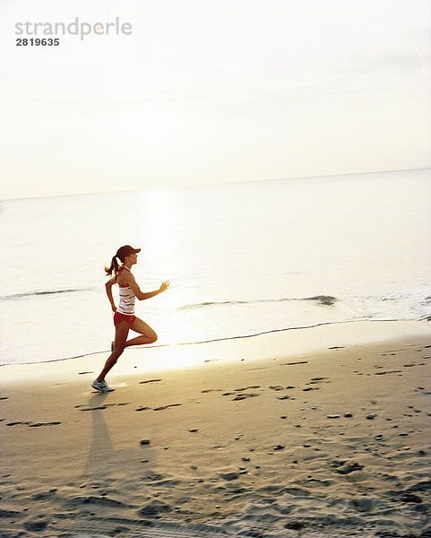 Eine Frau joggen am Strand.