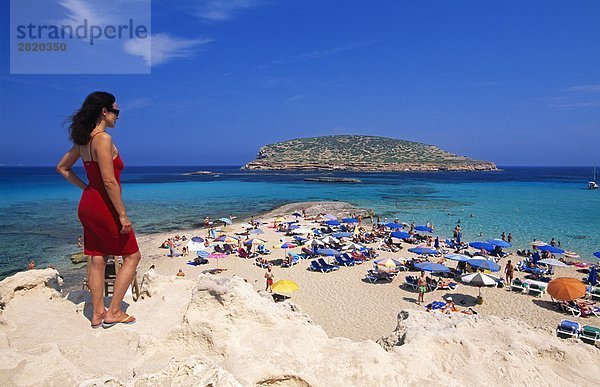 Frau blickt auf Menschen am Strand Cala Comte  Ibiza  Balearen Inseln  Spanien