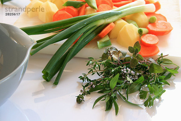 Segmente der Karotte mit Kartoffel und Frühlingszwiebel auf Schneidebrett