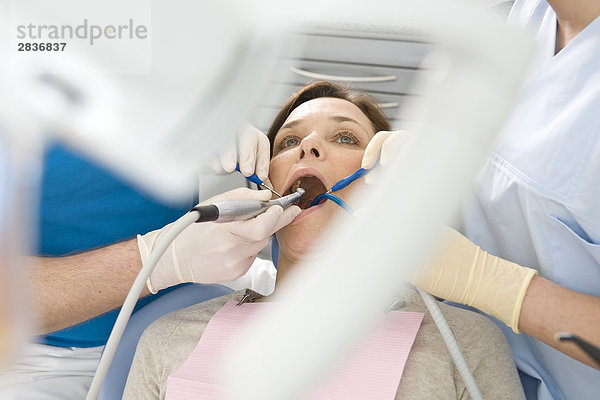 Männlich Zahnarzt und Assistent Untersuchung des Patienten Zähne