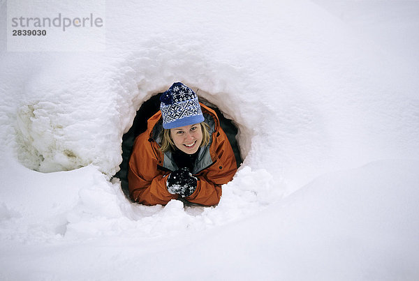 Eine Frau crawlt von einer 'Quinze' Schnee Hütte im Algonquin Provincial Park  Ontario  Kanada.