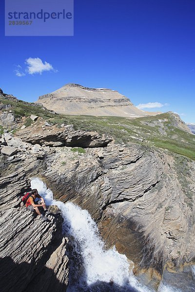 Wanderer Sitzung von einem Wasserfall am Dolomit Creek in den kanadischen Rocky Mountains  Banff-Nationalpark  Alberta  Kanada.