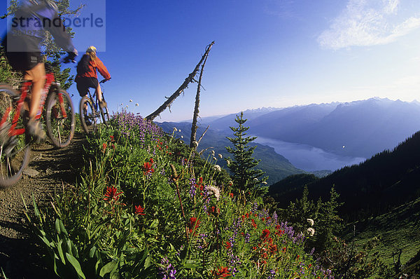 Zwei Frau Mountain-Biker am Idaho Peak mit Valhallas hinter  Slocan Tal  Kootenays  British Columbia  Kanada.