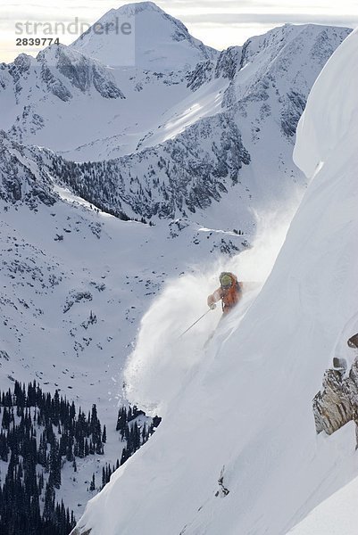 Professionelle Frau Skifahrer im Pulver auf alpine Steilhang mit Mt. McBride hinter  Valkyr Range  Selkirkgebirge  Kootenays  British Columbia  Kanada.
