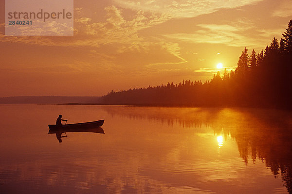 Kanufahrt auf Kindes See bei Sonnenaufgang Spiegelung  Ente Berg Provincial Park  Manitoba  Kanada.