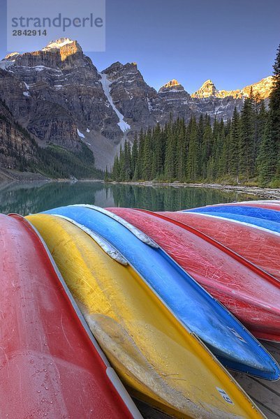 Frosty Kanus sitzen auf dem Dock bei Sonnenaufgang an Moraine Lake in das Ten Peaks Tal. Banff-Nationalpark  Alberta  Kanada.