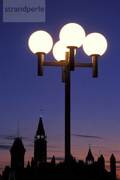 Laternenpfahl und Silhouette der Parlamentsgebäude in der Dämmerung  Ottawa  Ontario  Kanada
