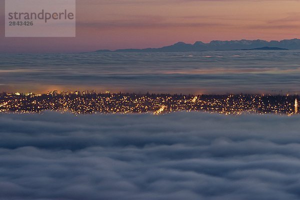 Lower Mainland und Vancouver bedeckt teilweise mit Nebel und Wolken bei Sonnenuntergang. Blick von Cypress Provincial Park in West Vancouver  British Columbia  Kanada