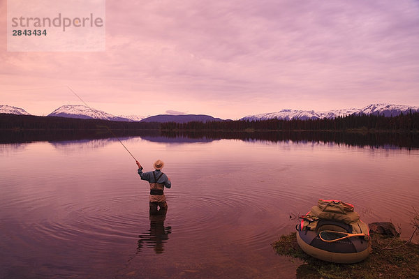 Fliegenfischer casting für Forelle im Morgengrauen  McBride See in der Nähe von Morice Lake  British Columbia