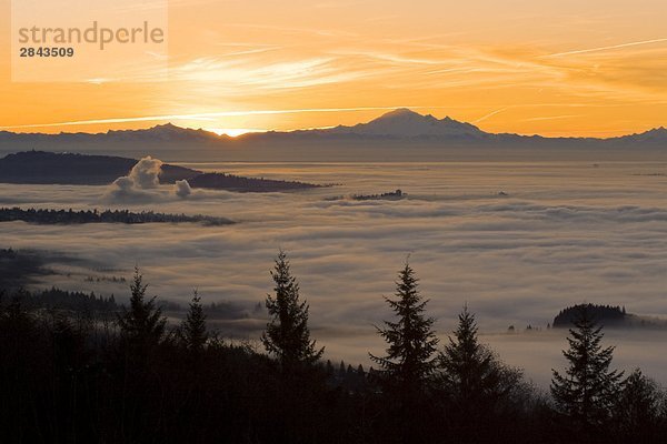 Lower Mainland und Vancouver bedeckt teilweise mit bewölkung wie Sonne hinter Mount Baker  Cypress Provincial Park in West Vancouver  British Columbia  Kanada aufgeht